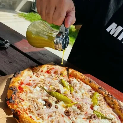 Adding the finishing touch to a freshly made pizza