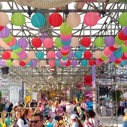A festival crowd beneath colourful hanging lanterns