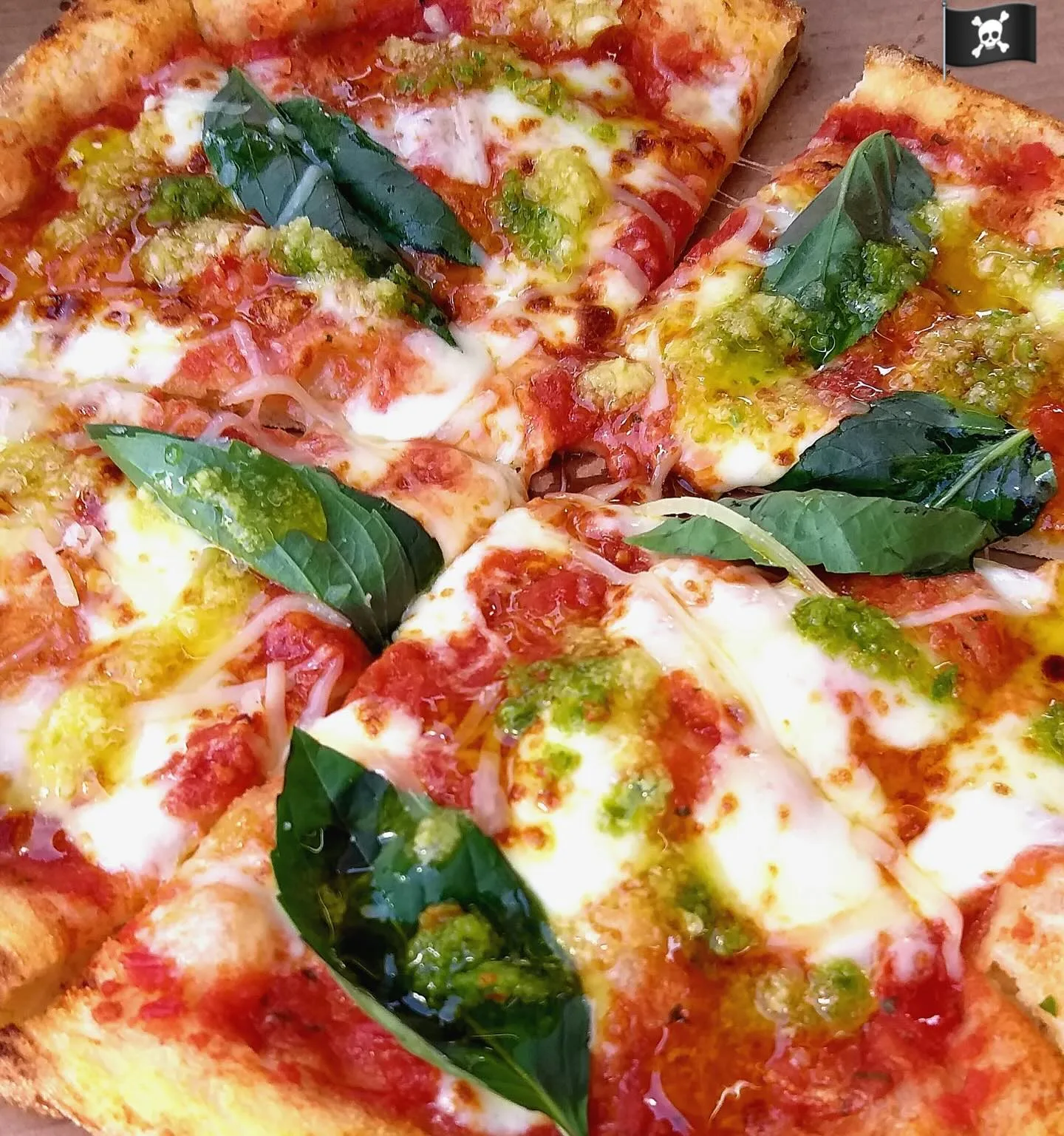 Sliced pizza with tomato, melted cheese and fresh basil